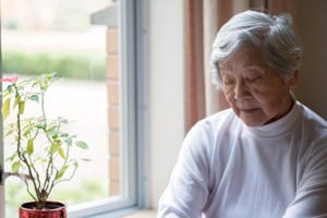 Serious senior woman in her 90s, with eyes closed.