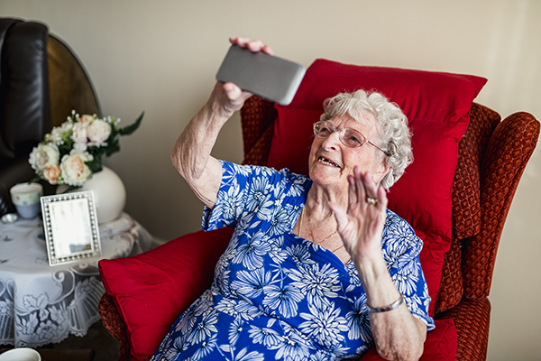 An elderly woman is using a smartphone.