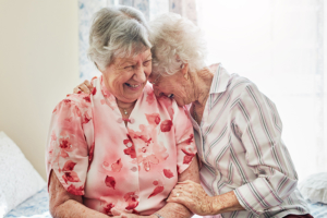 two happy elderly women spending time with each other at home