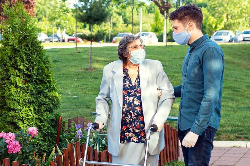 senior woman outside with male caregiver