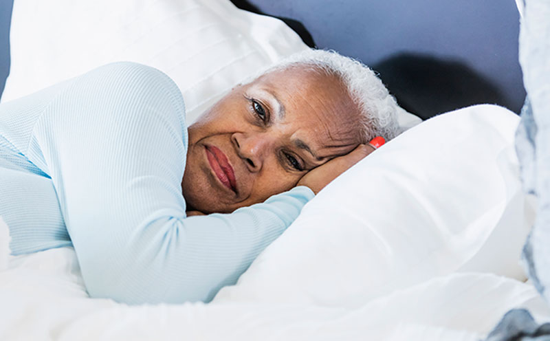 An older woman tries to sleep