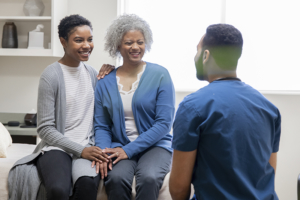 Medical professional talking to senior and her family caregiver