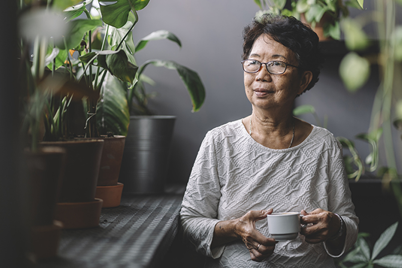 Senior woman holding a tea cup looking into the distance