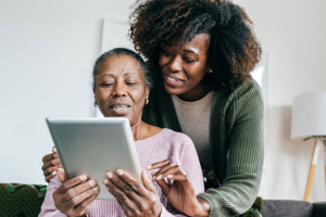 Family caregiver helping senior woman with aging in place technology