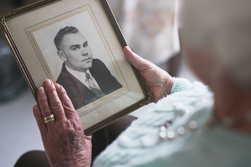 Senior woman looking at an old photo of a loved one