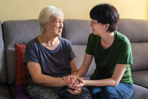 Family caregiver comforting senior with Alzheimer's