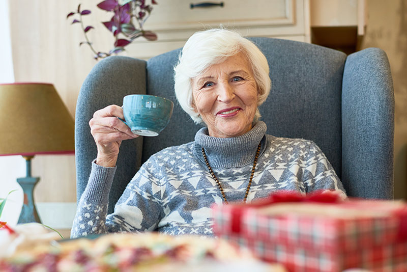 Happy senior woman drinking coffee
