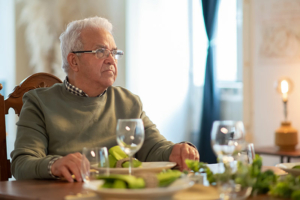 Senior man sitting alone at the dinner table