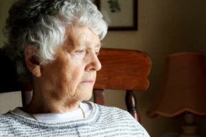 A woman experiencing both boredom and Alzheimer’s stares blankly into the distance.