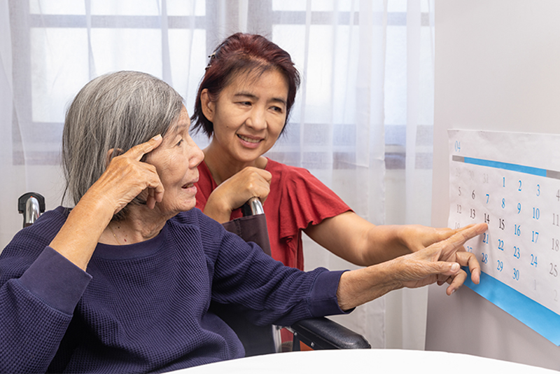 A caregiver helps guide a senior with dementia through reality orientation.