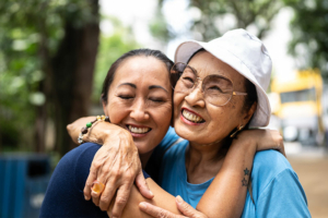 A young woman hugs a loved one with dementia.