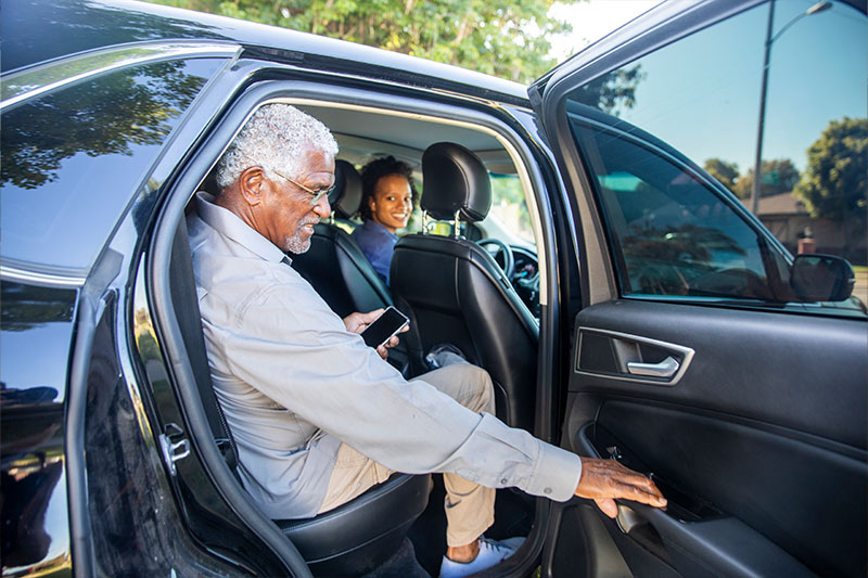 An older man receiving senior transportation services in Fort Lauderdale smiles as he prepares to go on an outing.