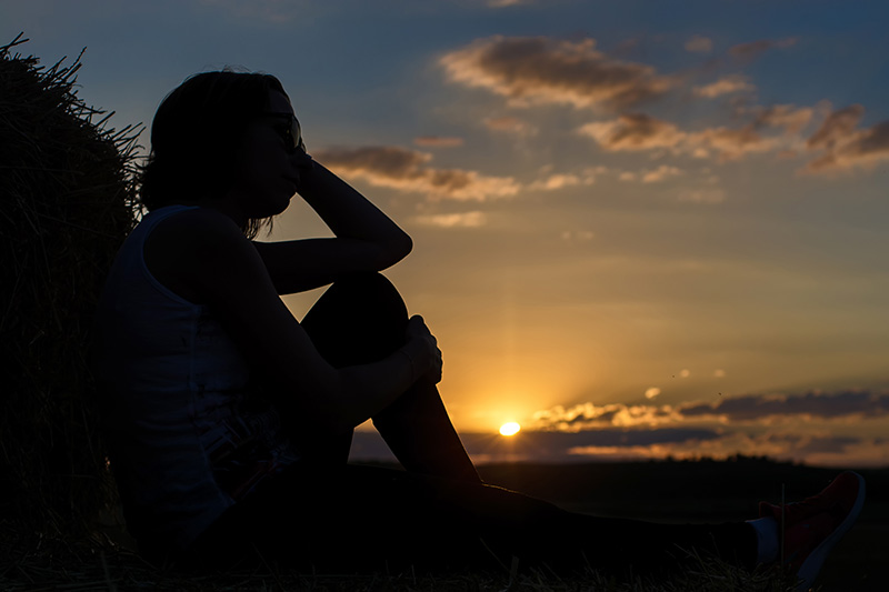 A woman sits in the waning sunlight, pondering what happens after caregiving ends.