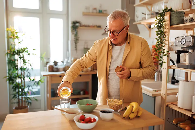 A senior man confidently makes himself a meal as a way of maintaining independence with dementia.