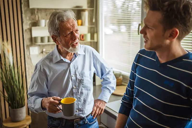 A family caregiver practices de-escalation techniques for caregivers while speaking with his aging father.